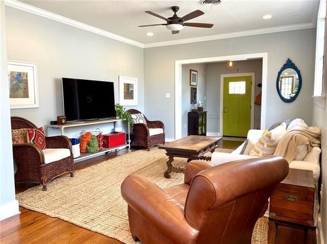 living room with crown molding, hardwood / wood-style floors, and ceiling fan