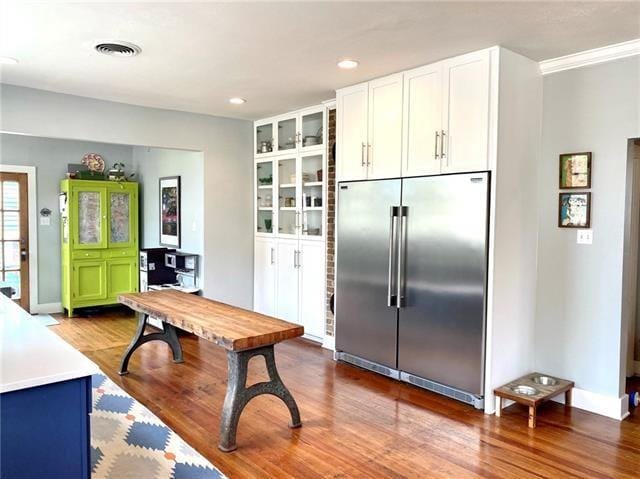 kitchen featuring white cabinetry, dark hardwood / wood-style flooring, built in shelves, and built in fridge