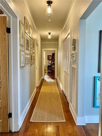 corridor featuring dark hardwood / wood-style flooring and ornamental molding