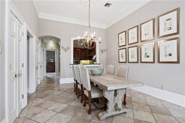 dining room with visible vents, baseboards, a chandelier, stone tile flooring, and arched walkways