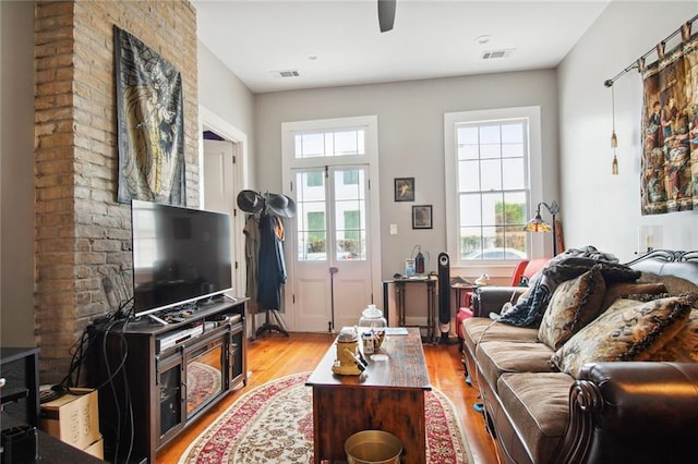 living room featuring ceiling fan, plenty of natural light, and light wood-type flooring