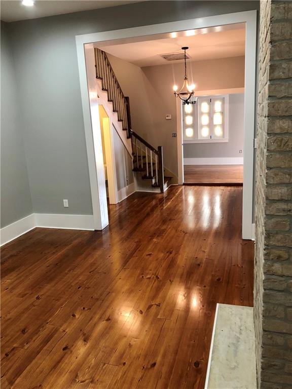 foyer with dark hardwood / wood-style floors and a chandelier