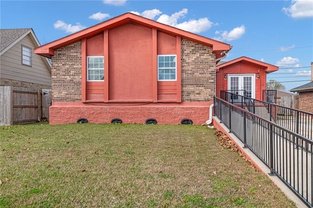 view of property exterior with a yard and french doors