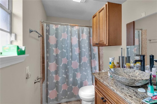 bathroom with toilet, vanity, tile patterned flooring, walk in shower, and a textured ceiling