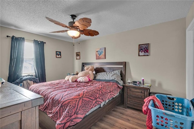 bedroom featuring a textured ceiling, ceiling fan, and hardwood / wood-style flooring