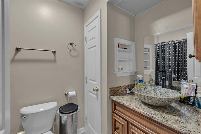 bathroom featuring toilet, vanity, and a shower with shower curtain