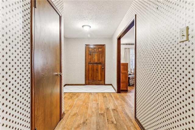 hallway featuring a textured ceiling and light hardwood / wood-style flooring