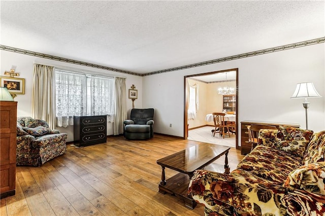 living room featuring a textured ceiling, an inviting chandelier, and wood-type flooring