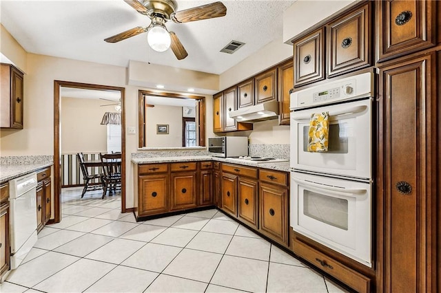 kitchen with ceiling fan, light tile patterned flooring, light stone counters, and white appliances