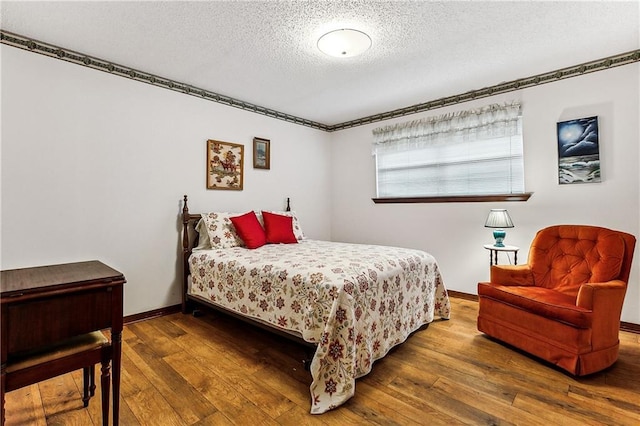 bedroom featuring a textured ceiling and dark wood-type flooring