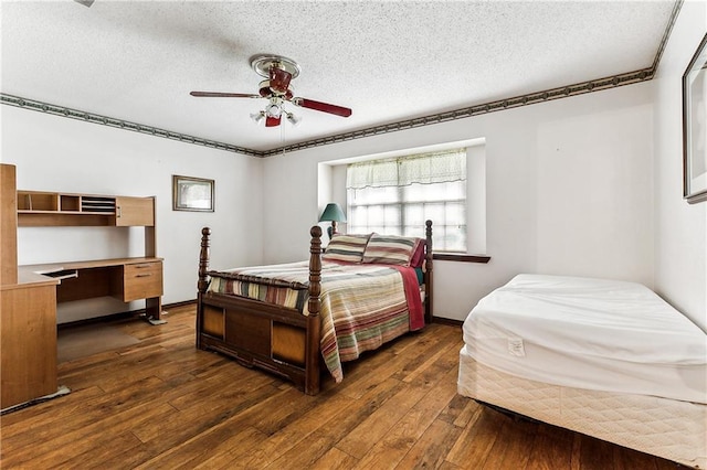 bedroom with ceiling fan, a textured ceiling, and dark hardwood / wood-style floors