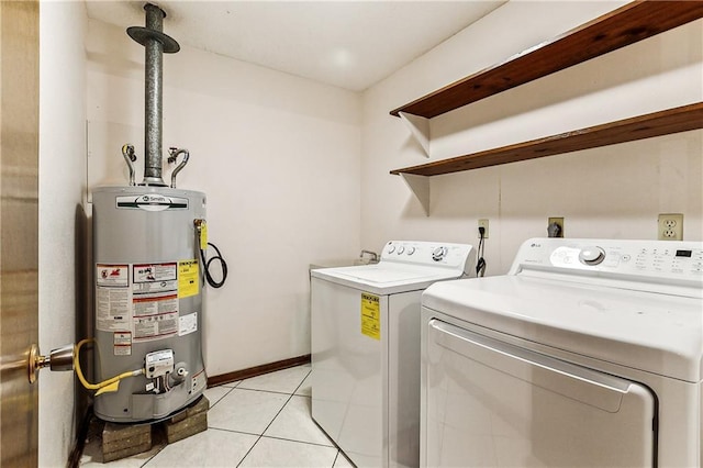 washroom featuring water heater, light tile patterned flooring, and washing machine and dryer