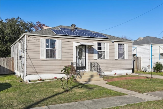 bungalow with a front yard and solar panels