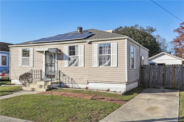 bungalow with a front yard and solar panels