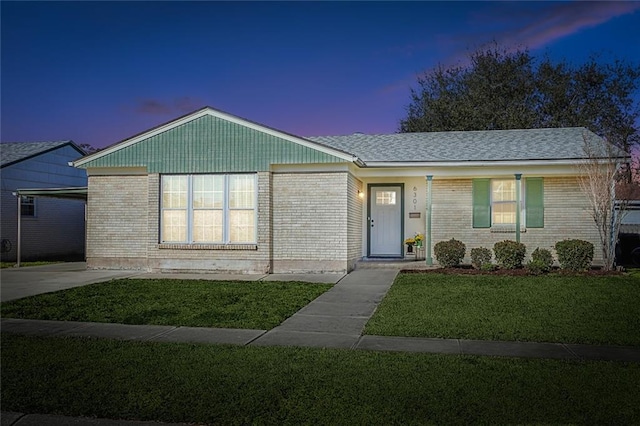 single story home featuring a carport and a lawn