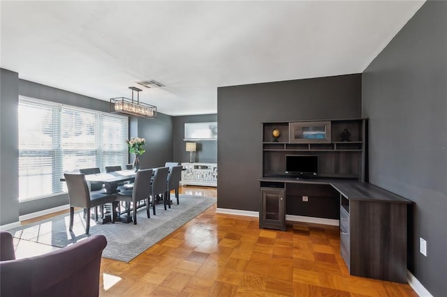 dining space with light parquet flooring and a notable chandelier