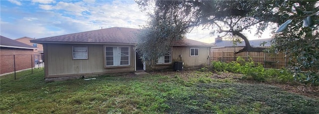 back of house featuring a lawn and central AC