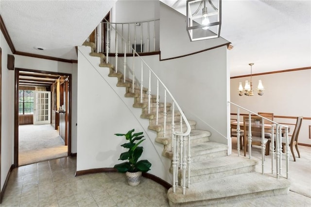 staircase with carpet, a textured ceiling, a chandelier, and ornamental molding