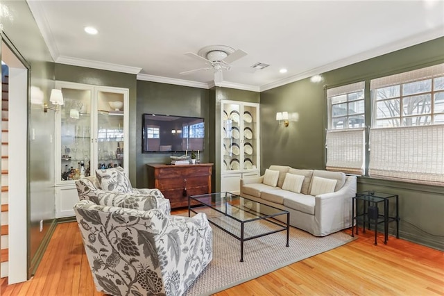 living room with ceiling fan, ornamental molding, and wood-type flooring