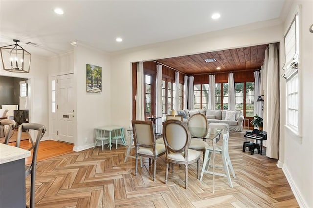 dining area featuring light parquet flooring, crown molding, and an inviting chandelier