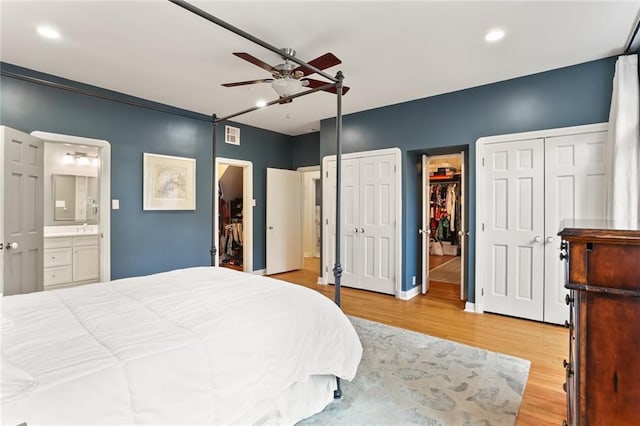 bedroom featuring ceiling fan, light hardwood / wood-style floors, and ensuite bathroom