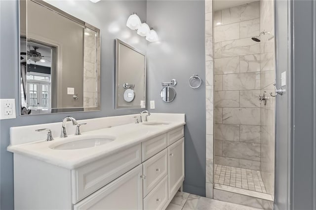 bathroom with ceiling fan, vanity, and a tile shower