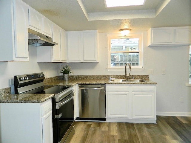 kitchen featuring white cabinets, dark hardwood / wood-style flooring, stainless steel appliances, dark stone countertops, and sink