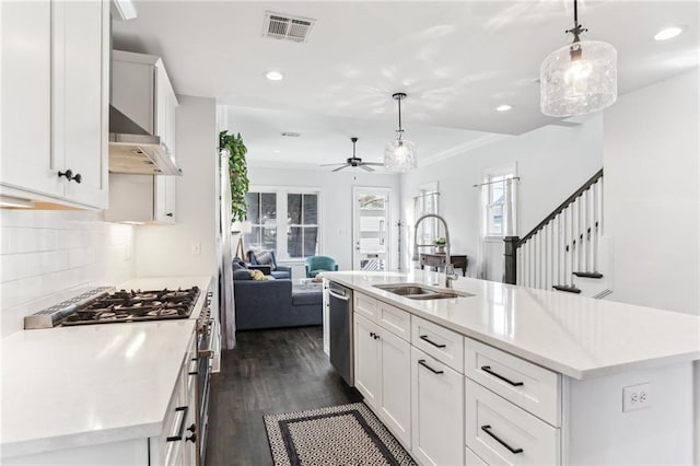 kitchen with sink, white cabinets, pendant lighting, and a kitchen island with sink