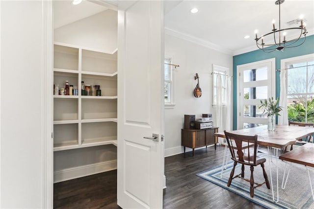 dining room featuring an inviting chandelier, a wealth of natural light, crown molding, and dark hardwood / wood-style flooring