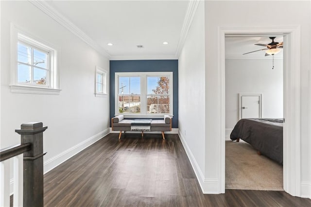 hall featuring dark wood-type flooring, ornamental molding, and a healthy amount of sunlight