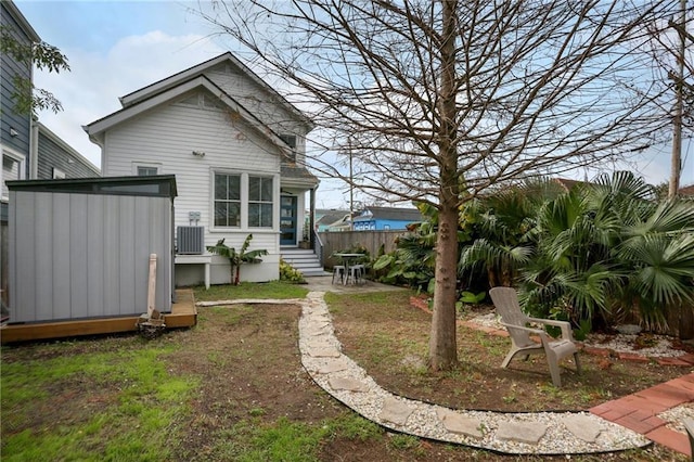 exterior space with central AC and a storage shed