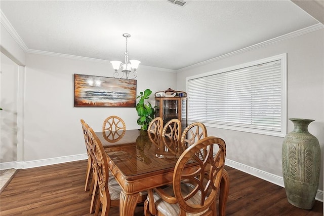 dining room with dark hardwood / wood-style floors, ornamental molding, and a notable chandelier