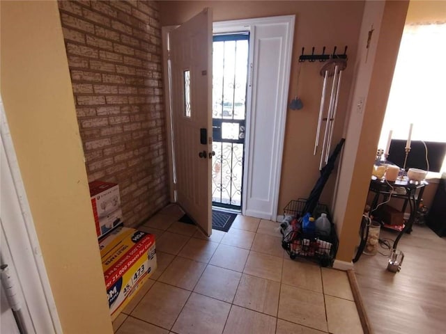 tiled foyer entrance with brick wall