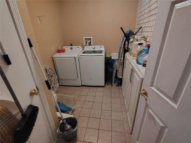 clothes washing area featuring cabinets, independent washer and dryer, and light tile patterned flooring