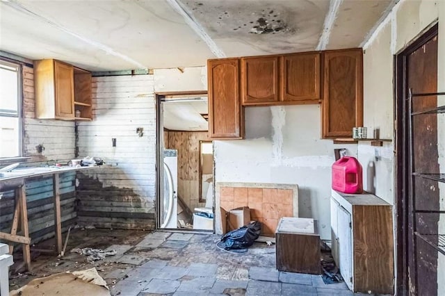 kitchen with washer / dryer and wooden walls