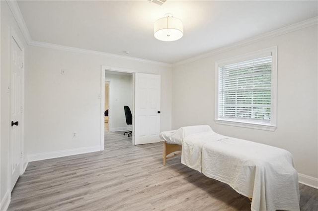 bedroom featuring crown molding and light hardwood / wood-style floors