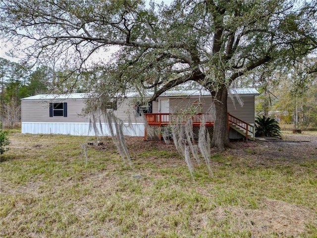 back of house featuring a wooden deck and a lawn