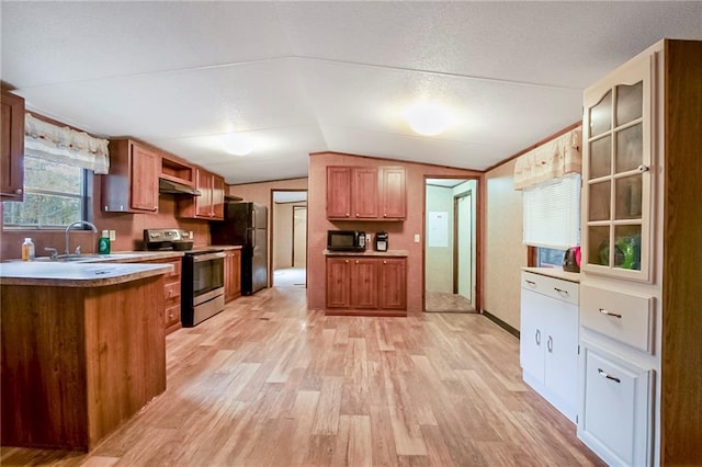 kitchen featuring a sink, light wood-style flooring, black appliances, and vaulted ceiling