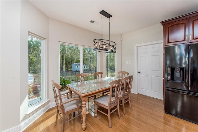 dining area featuring an inviting chandelier and light hardwood / wood-style flooring