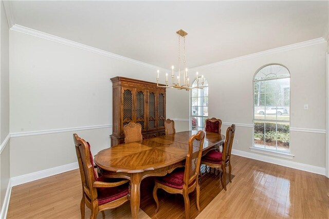 dining area featuring a chandelier, light hardwood / wood-style floors, and ornamental molding