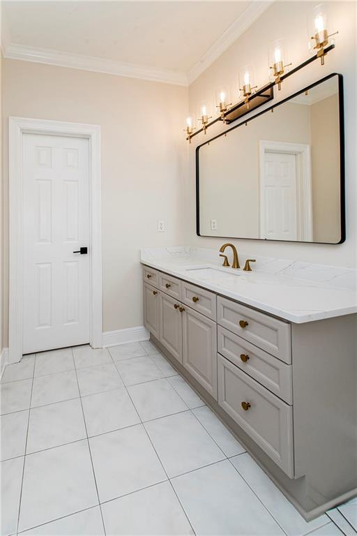 bathroom with tile patterned floors, vanity, and crown molding