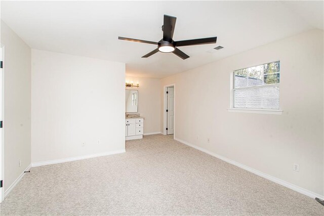 spare room with ceiling fan and light colored carpet