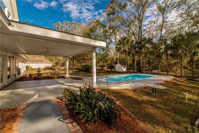 view of swimming pool featuring a patio area and a storage shed