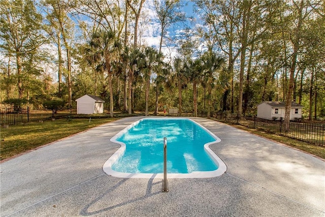 view of swimming pool with a lawn and a shed