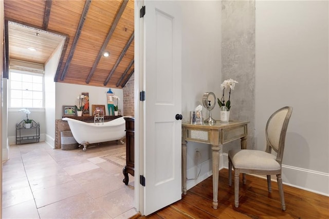 bathroom featuring a bathing tub, vaulted ceiling, and wood ceiling