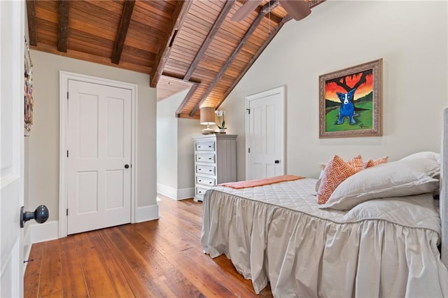 bedroom with hardwood / wood-style flooring, vaulted ceiling with beams, and wooden ceiling