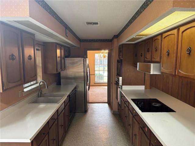 kitchen featuring a notable chandelier, black appliances, and sink