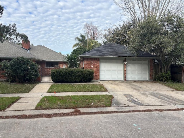 view of front of house with fence, concrete driveway, and brick siding