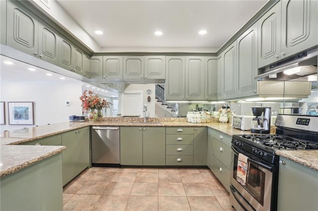 kitchen with light stone counters, sink, appliances with stainless steel finishes, and green cabinetry