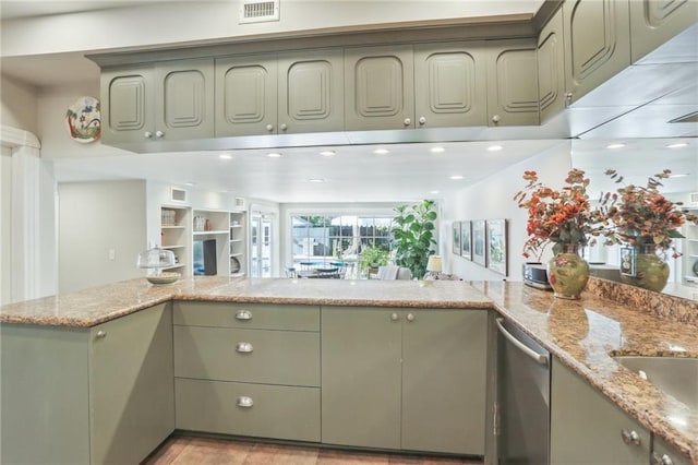 kitchen with kitchen peninsula, dishwasher, light stone counters, and green cabinetry